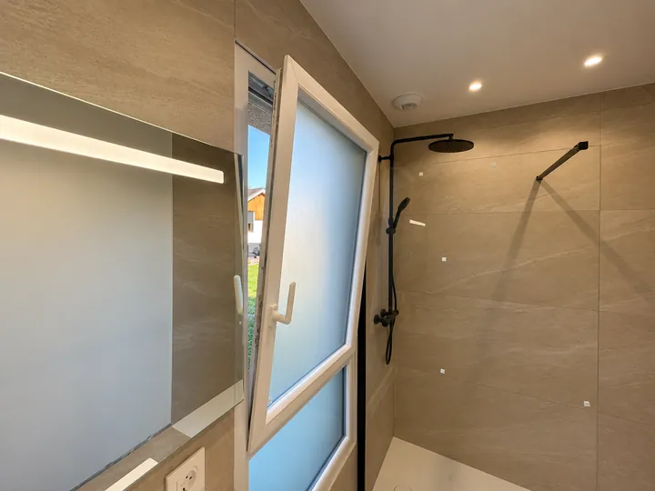 Salle de bain beige avec douche pluie